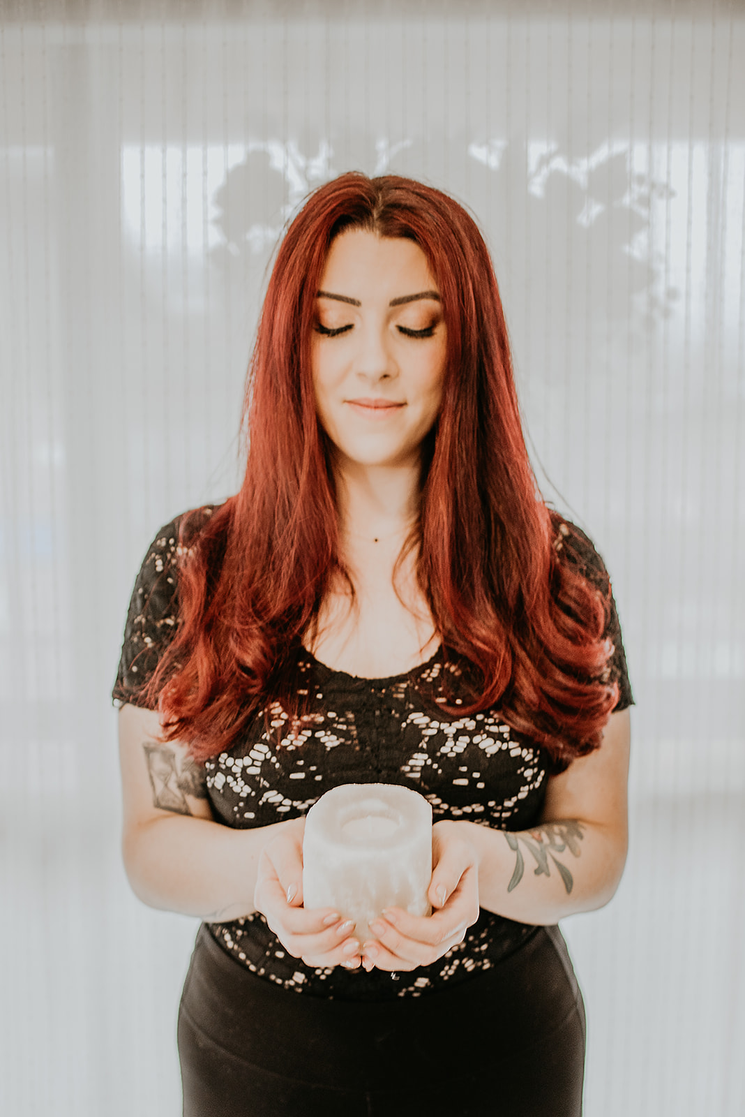 Chiara, owner and esthetician at Rituale Olistica & Spa, holding a candle